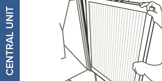 An illustration of hands pushing a furnace filter into its slot in a central unit.
