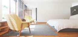 Une chambre ensoleillée avec deux chaises.
